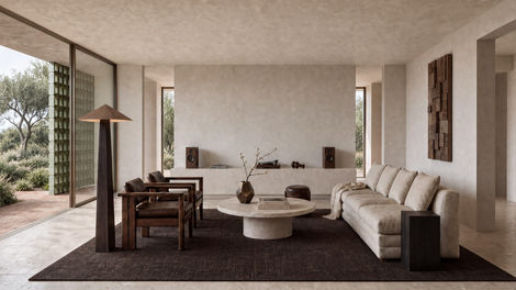 Contemporary living room conceived for Ibiza with low furniture, dark timber, natural stone and restrained Mediterranean materials.