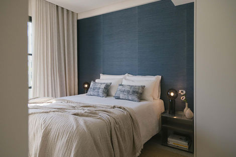 Mediterranean-style bedroom with blue accent wall, natural fabrics, and soft lighting — Interior Design Mallorca by suō.