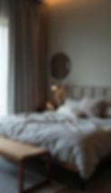 A cozy and minimalist bedroom with a large bed covered in soft, neutral-colored bedding.jp