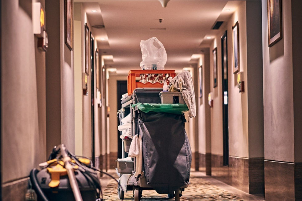 A hotel hallway with a janitorial cart and a carpet steam cleaner