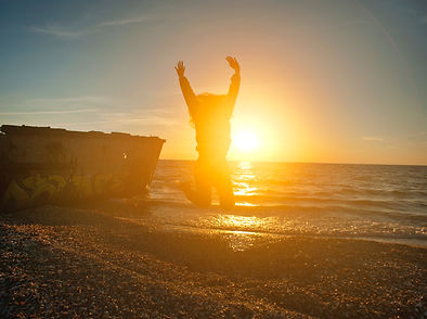 person-jumping-on-seashore-during-golden