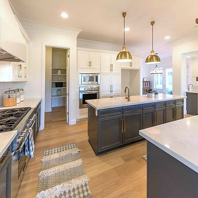 Large dark grey island with gold pendant lights.