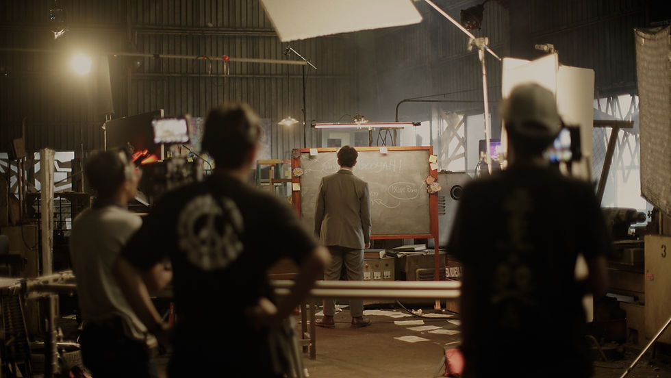 Crew watching an actor on a lit set during a shoot