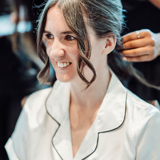 Hair stylist creating a hair updo for a bride
