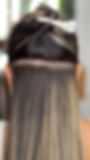 Hair extensions on woman's head, showing hair strands, beauty services, close up view