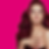 A stunning woman with wavy burgundy hair poses against pink, exuding beauty and confidence