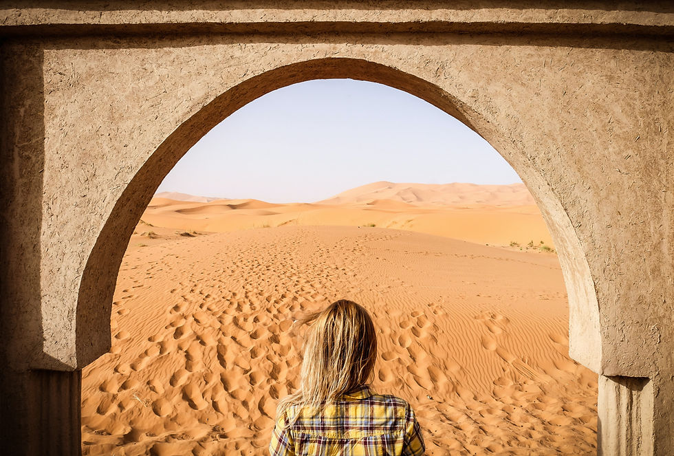 woman looking through desert archway