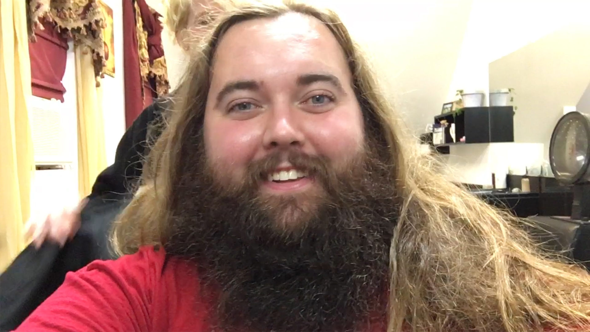 man with big beard and long hair preparing for haircut at hair salon