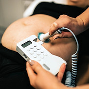 Pregnant woman being examined by midwife. Pregnant Woman Having Ultrasound Scan Covid-19 v