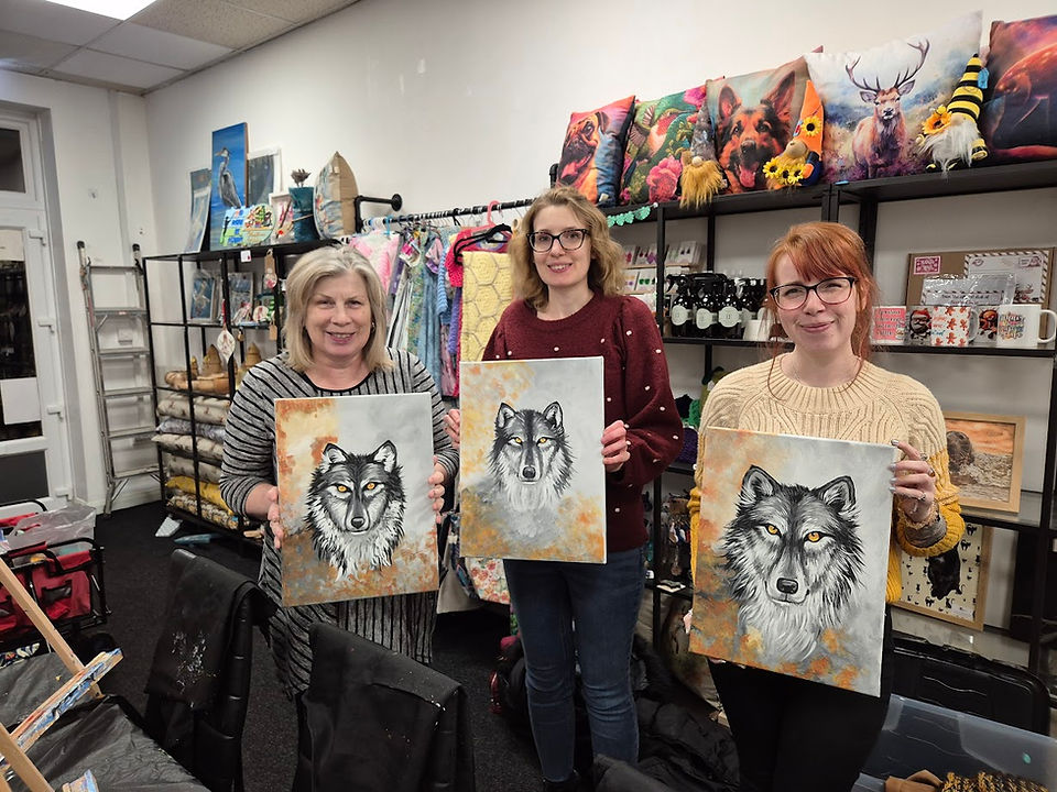 Group of three women holding wolf paintings