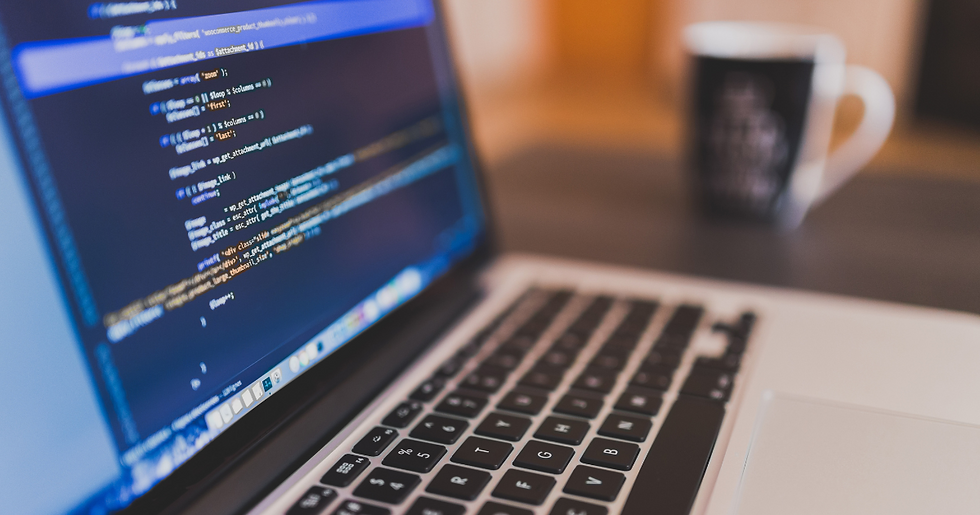 A laptop displaying lines of code sits on a desk, with a cup of coffee in the background, creating a perfect setup for a productive coding session.