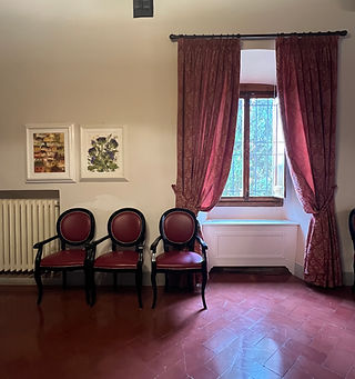 3 Stühle, dahinter 2 Bilder und ein Fenster mit rotem Vorhang