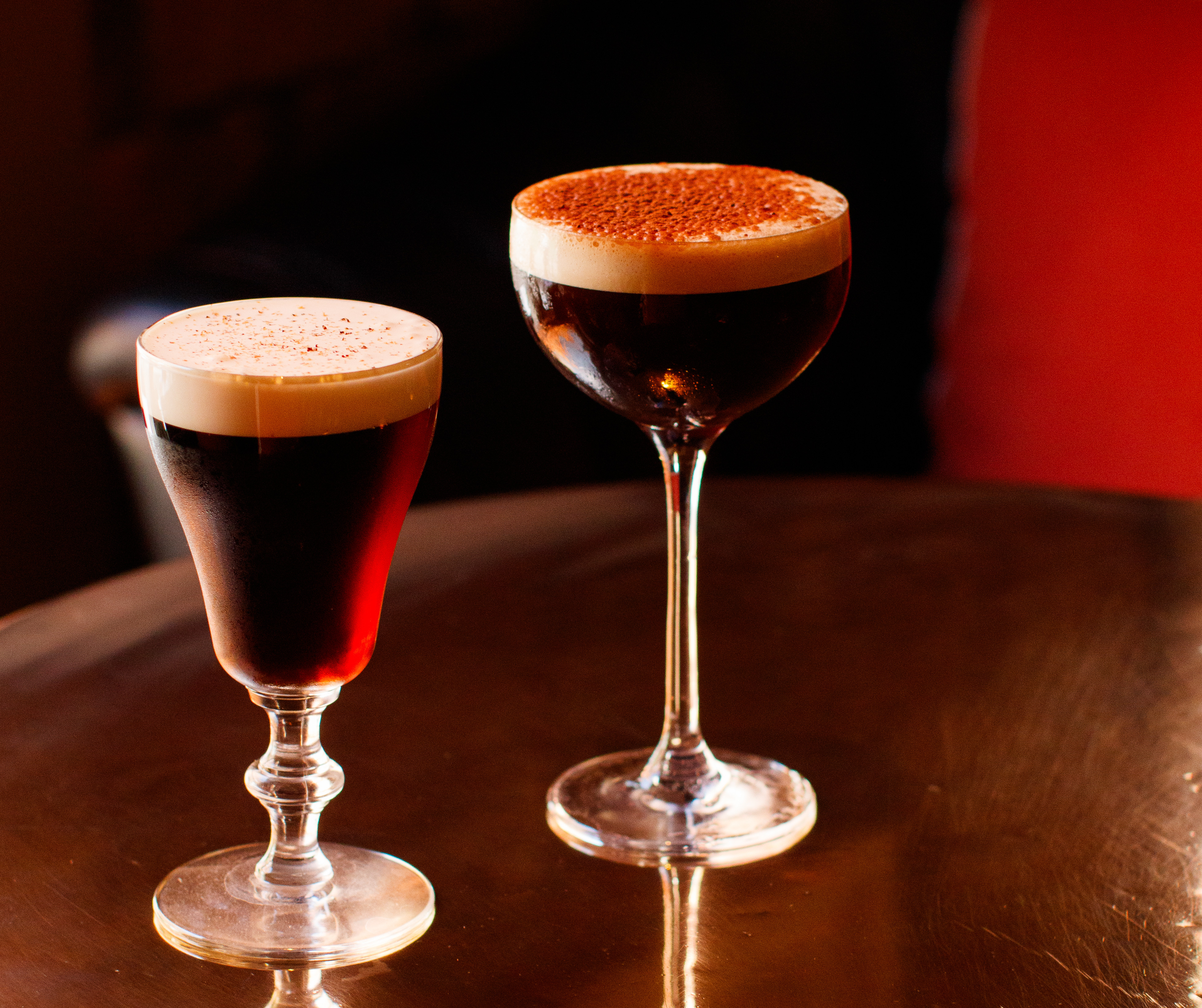Close-up of two festive cocktails with citrus and herb garnishes