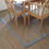 Thumbnail: Natural seagrass rug with a light blue border under a dining table and chairs.