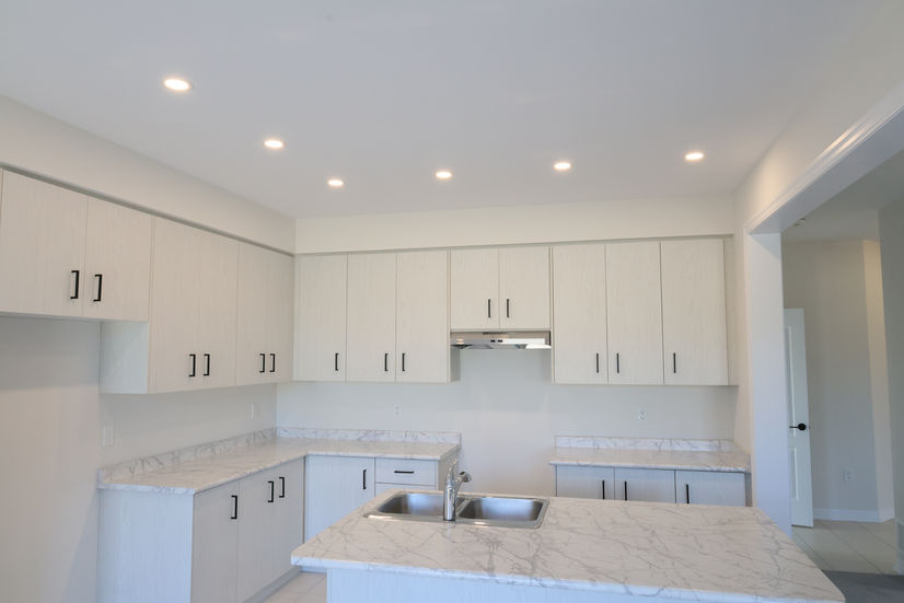 Modern white kitchen with island and recessed lighting