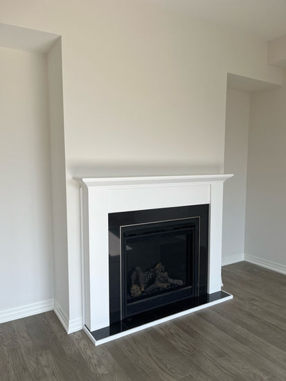 Modern white fireplace with black insert and wood floor