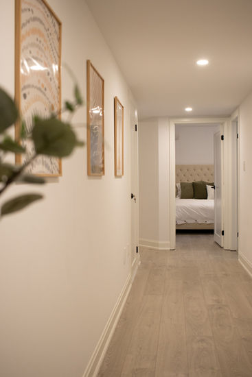 Bright hallway with framed art and bedroom view