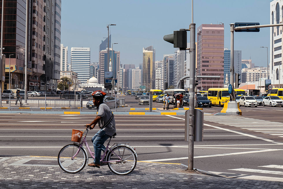 A man riding a bike down a street next to tall buildings
