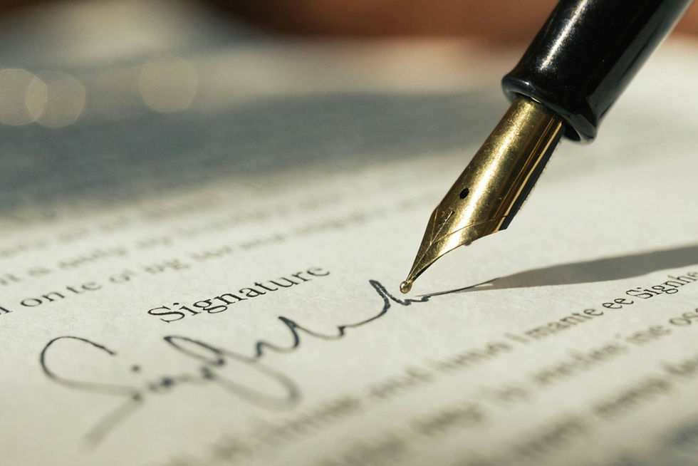 A fountain pen writes a signature on a document.