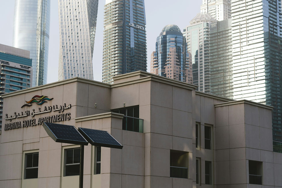 Modern skyscrapers rise behind a low-rise building.