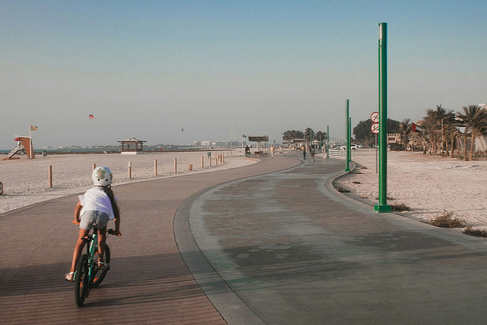 Girl riding on a bike along the beach in Dubai