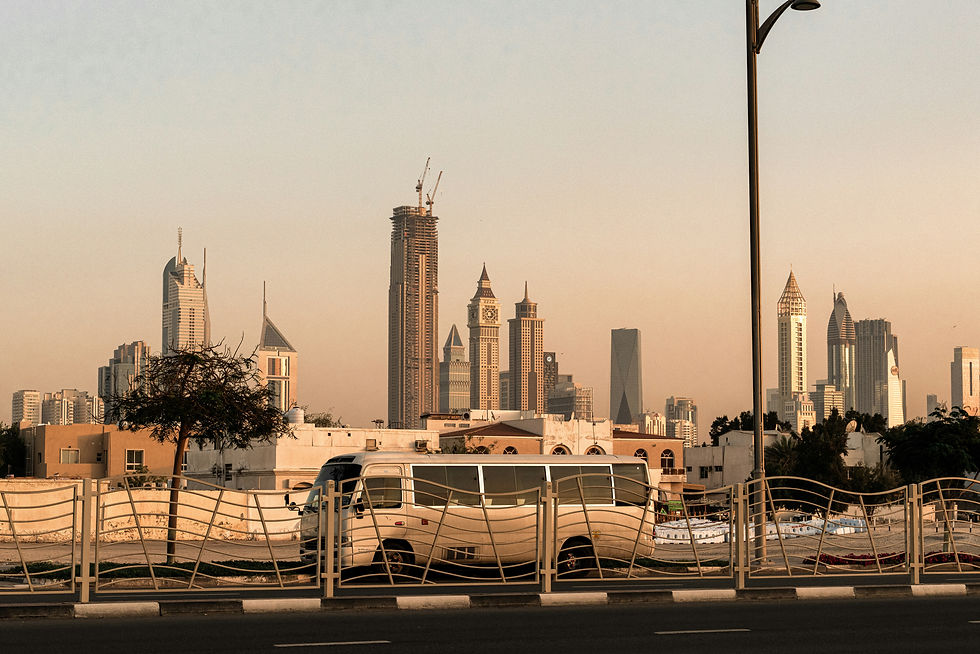 Modern city skyline and a bus on a road.