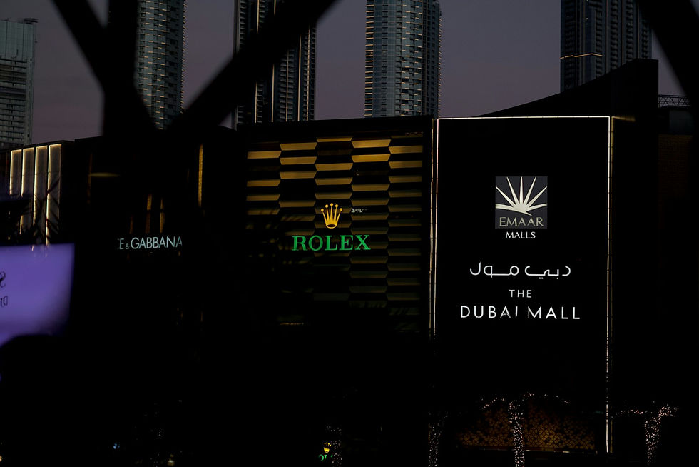 Dubai Mall Emaar exterior at night with Rolex and luxury brand signs