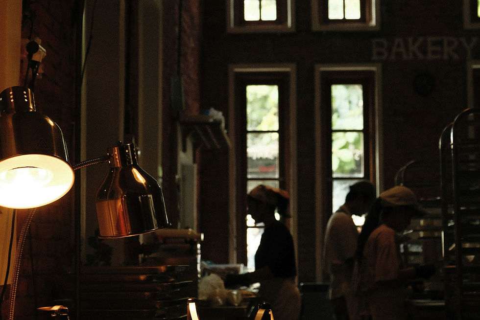 Pastries displayed in a dimly lit bakery with staff working