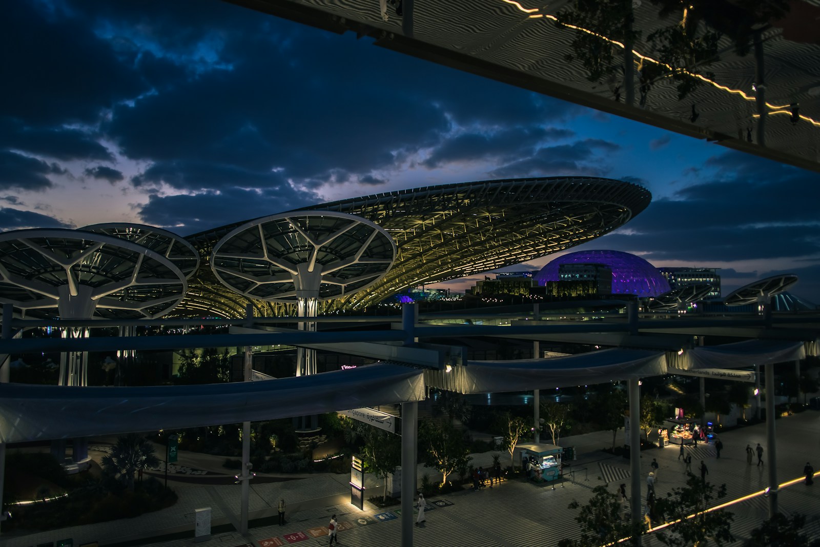 Futuristic pavilion canopies and illuminated dome structure at twilight in Dubai