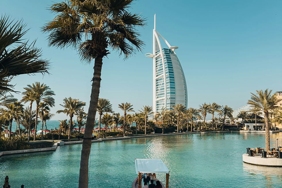 Burj Al Arab framed by palms and turquoise water—iconic Dubai luxury landmark in bright daylight.