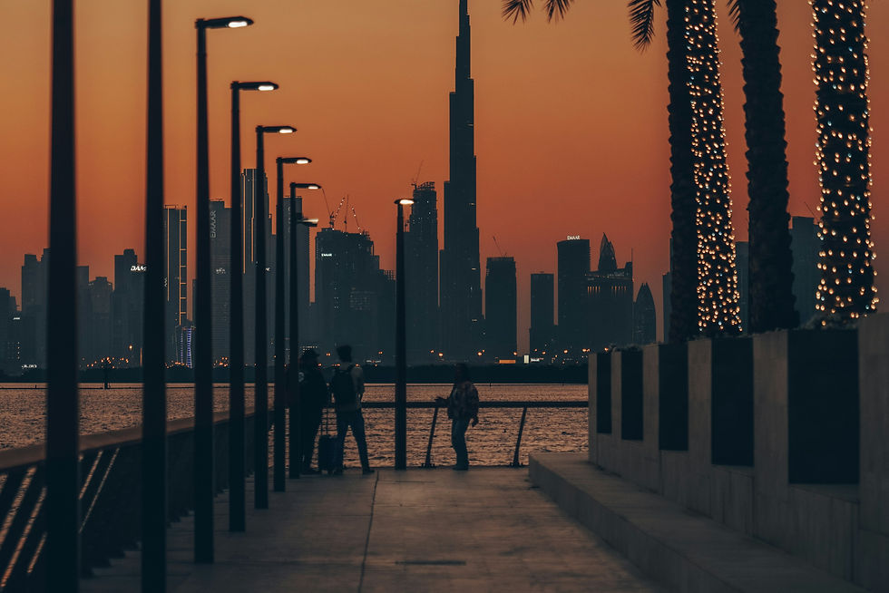 a couple of people walking down a sidewalk next to palm trees