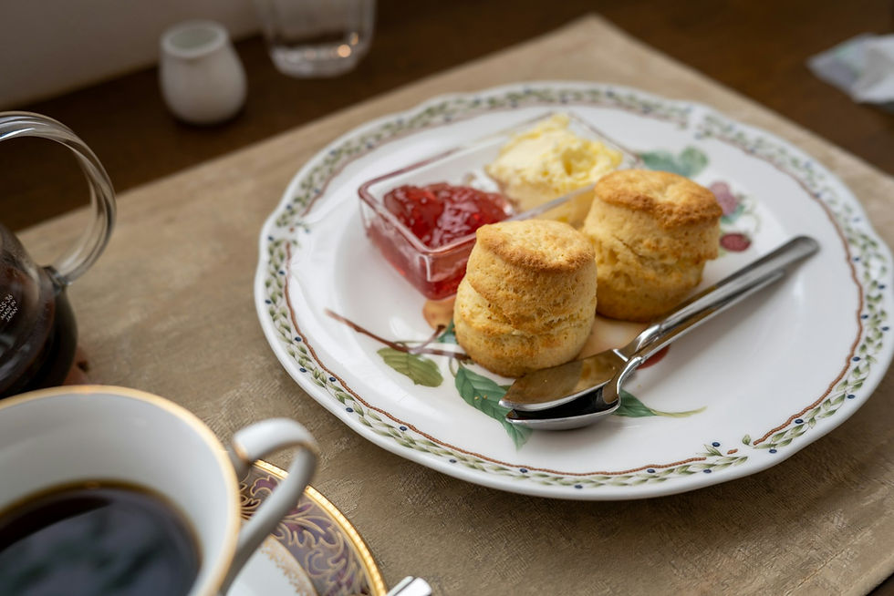 Fresh scones on floral plate with tea service — representative Ritual Afternoon Tea course; not the venue's own photo.