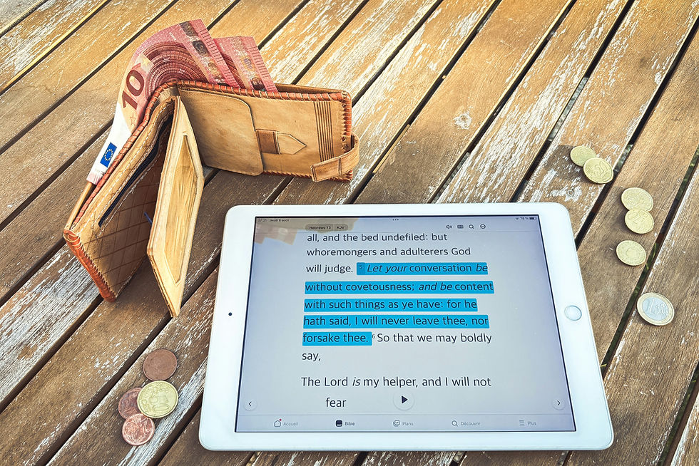 Wallet, tablet with financial data, and coins on wooden table.