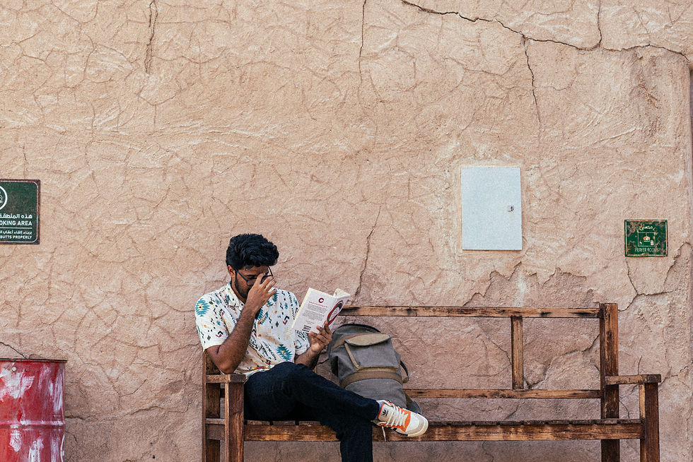 a person sitting on a bench reading a newspaper
