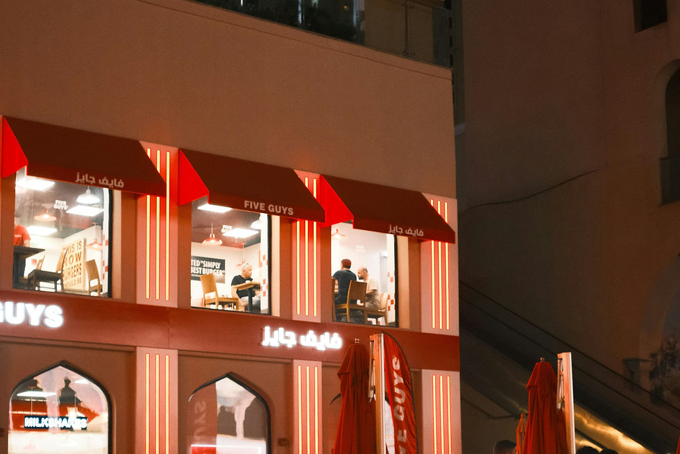 A group of people walking past a building at night
