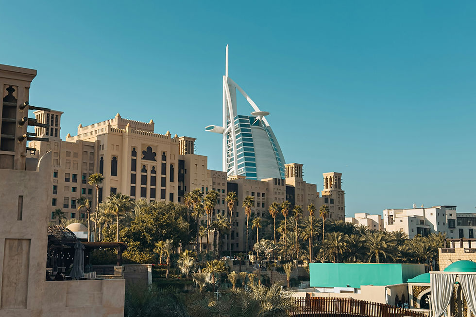 Burj Al Arab framed by palms and turquoise water—iconic Dubai luxury landmark in bright daylight.