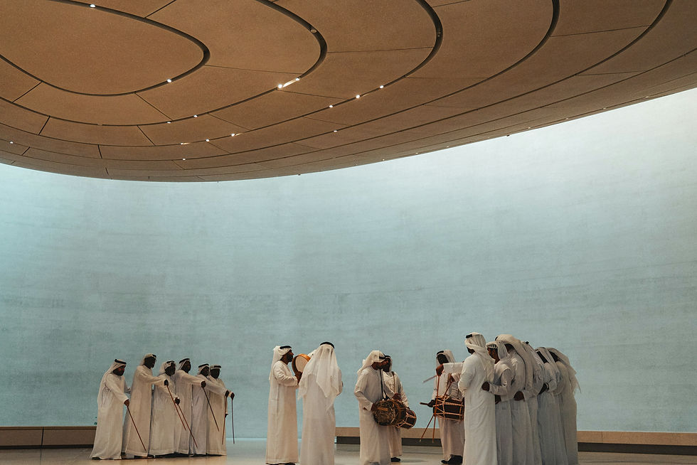 Men in white robes gather under a circular ceiling.