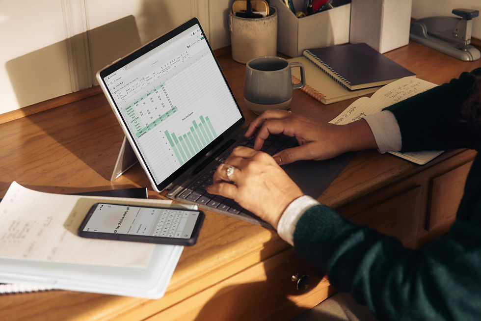 Person working on laptop at a wooden desk.