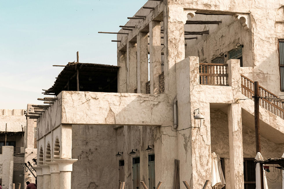 Historic middle eastern building with wind tower by the water.