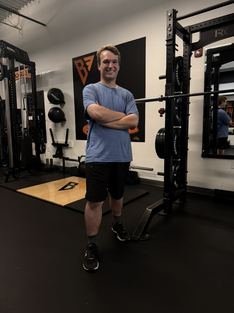 A row of professional dumbbells in a sleek modern gym setting with focused lighting.