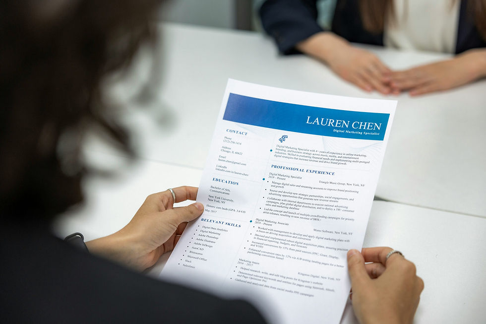 Woman looks over resume during an interview with a prospective candidate.