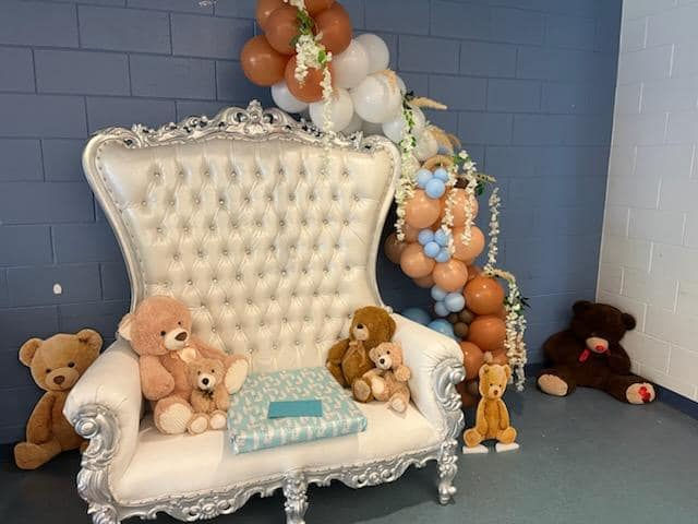 Elegant sofa with teddy bears and balloon decorations.