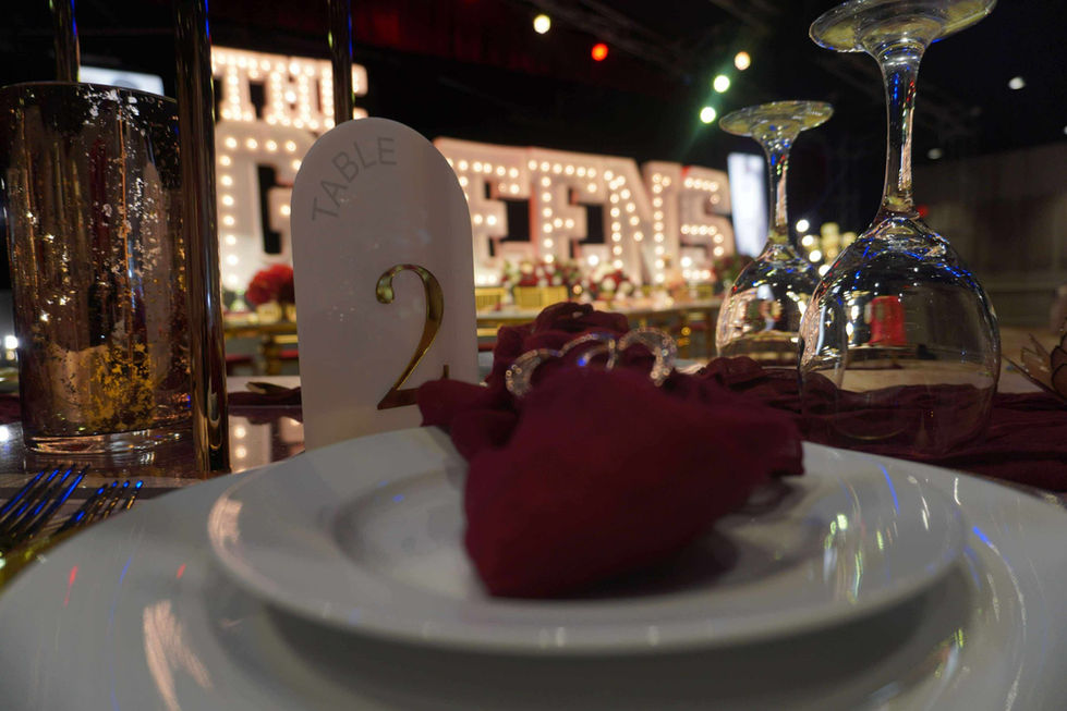 Elegant table setting with decorative lighting in background.
