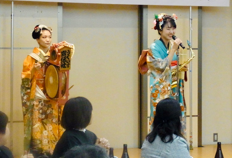 新年会の余興のステージショーでトークをするチンドン屋