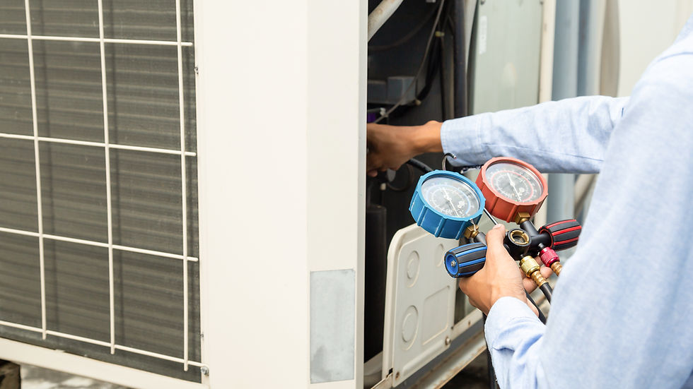 Air repair mechanic using measuring equipment for filling industrial factory air conditioners and checking maintenance outdoor air compressor unit.