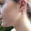 Thumbnail: model wearing signature skull silver earrings with grey pearl dropper