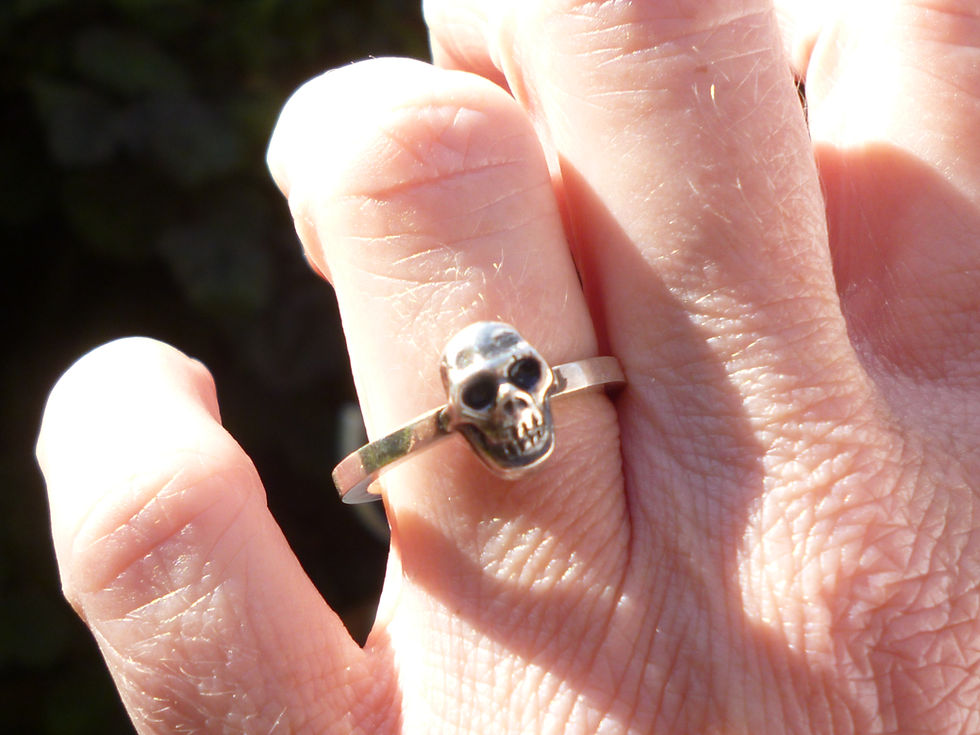 model wearing single signature skull ring on 2 mm band