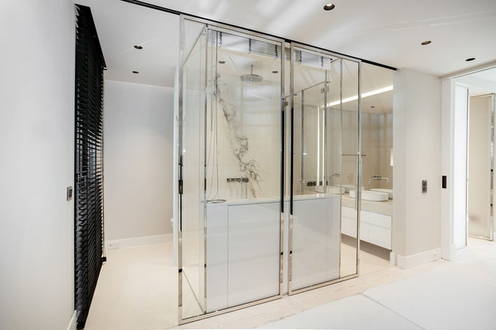 Ahrensburger Glasbau Drehtür aus Glas, Hochglanzpoliertes Profilrahmensystem in einem luxuriösen Badezimmer.