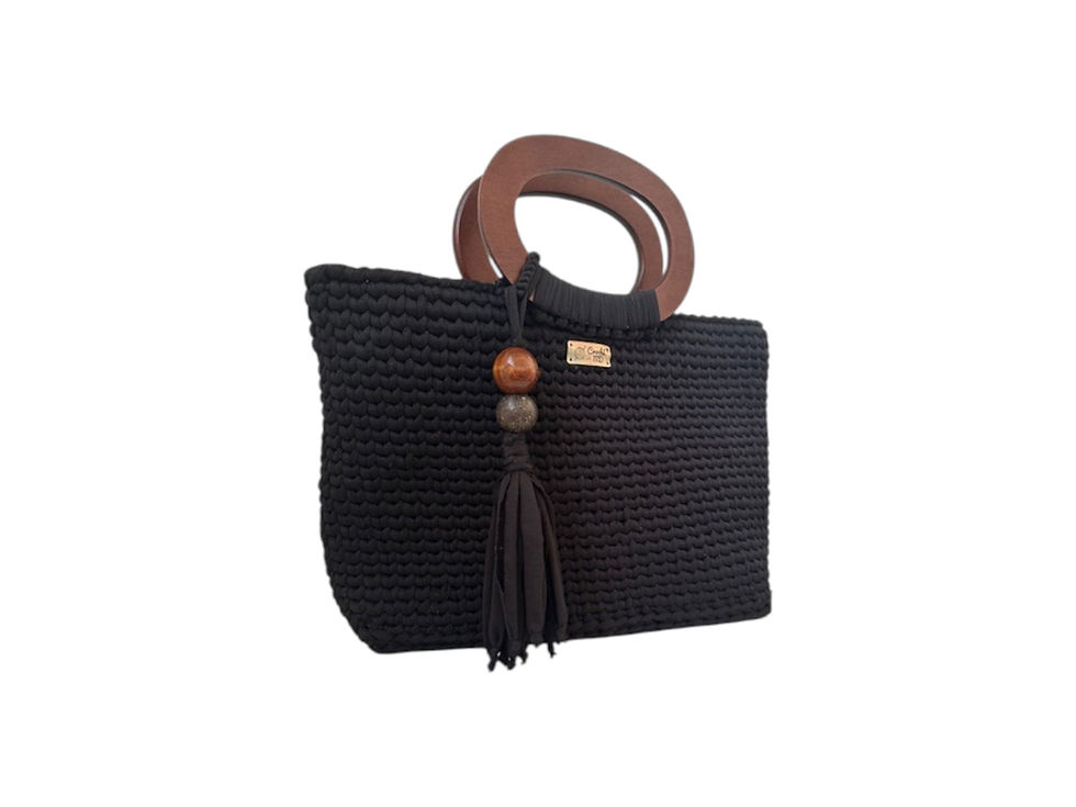Vista lateral da bolsa Vibration MD Création em crochê preto mostrando a alça oval de madeira e o pingente artesanal lateral.