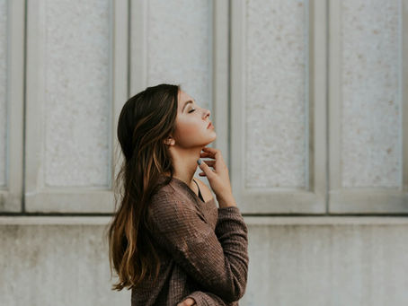 woman-in-brown-long-sleeved-top-standing-beside-wall